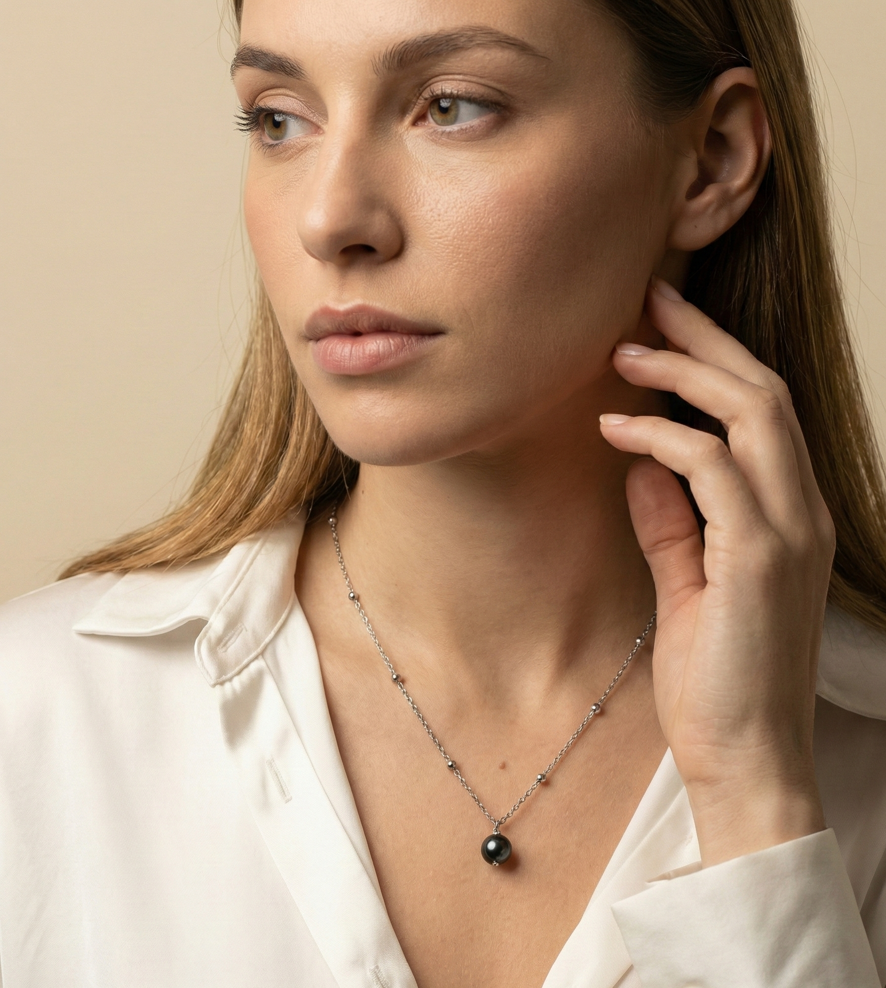 Model wearing single black round pearl pendant on dainty silver beaded chain necklace