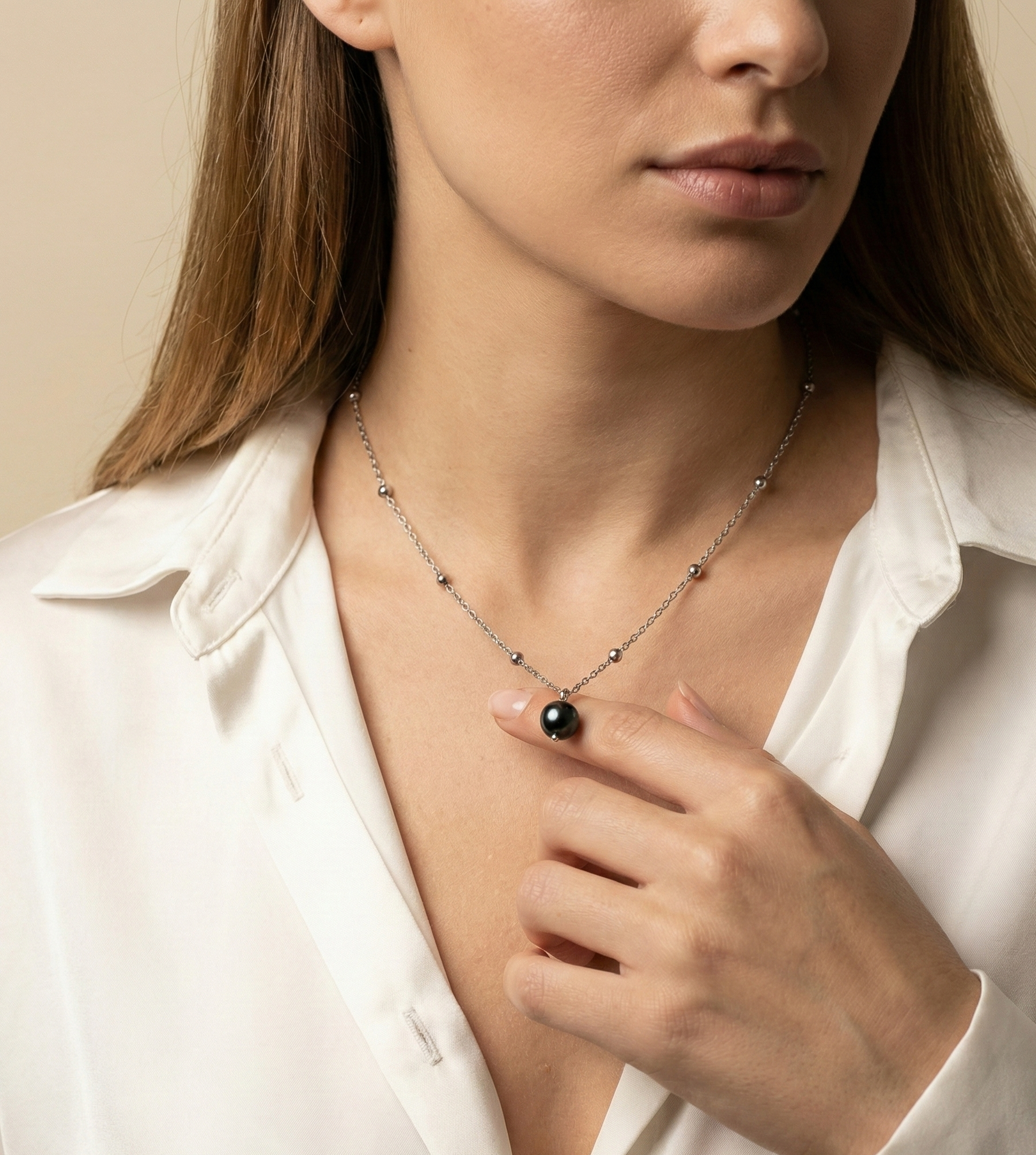 Model wearing single black round pearl pendant on dainty silver beaded chain necklace
