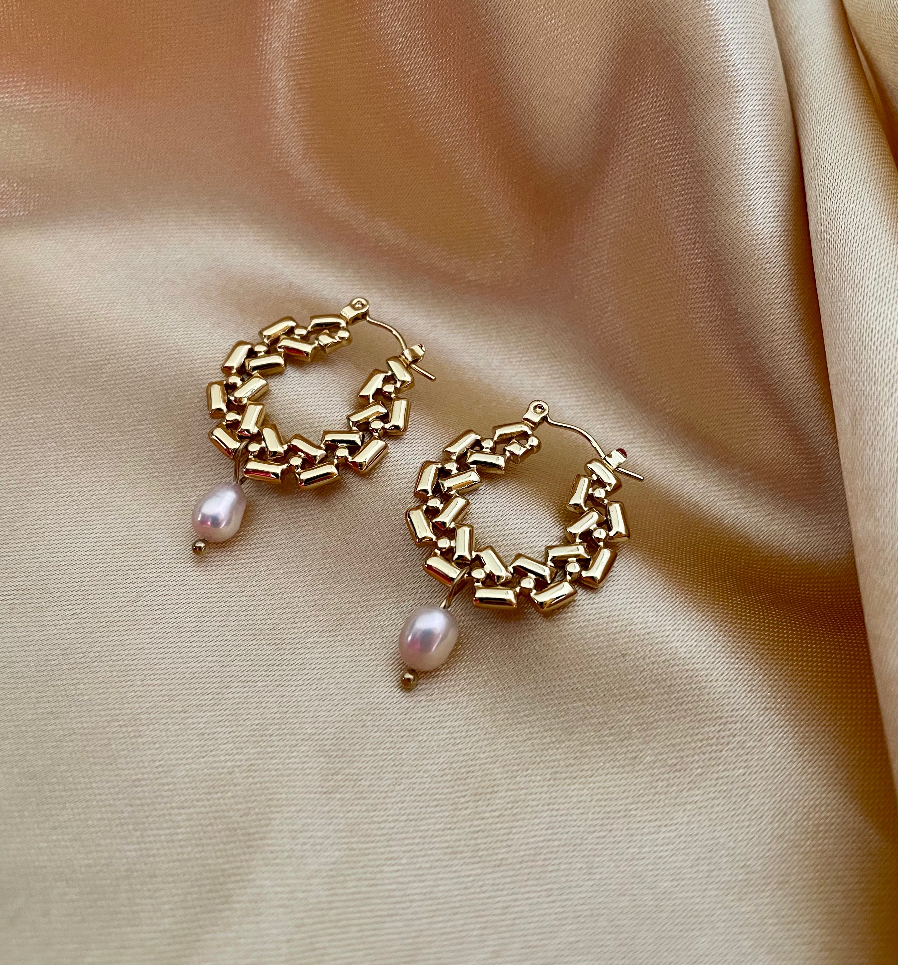 Close-up detail of AAA quality oval champagne freshwater pearl attached to PVD 18k gold plated stainless steel hardware. High-lustre pearl jewelry texture