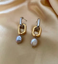 Close-up detail of mixed metal chain link earrings with grey pearl drops worn on the ear.