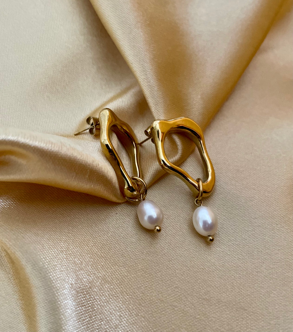 woman wearing sculptural gold earrings with a delicate freshwater pearl drop, ideal for weddings, office and casual night outs