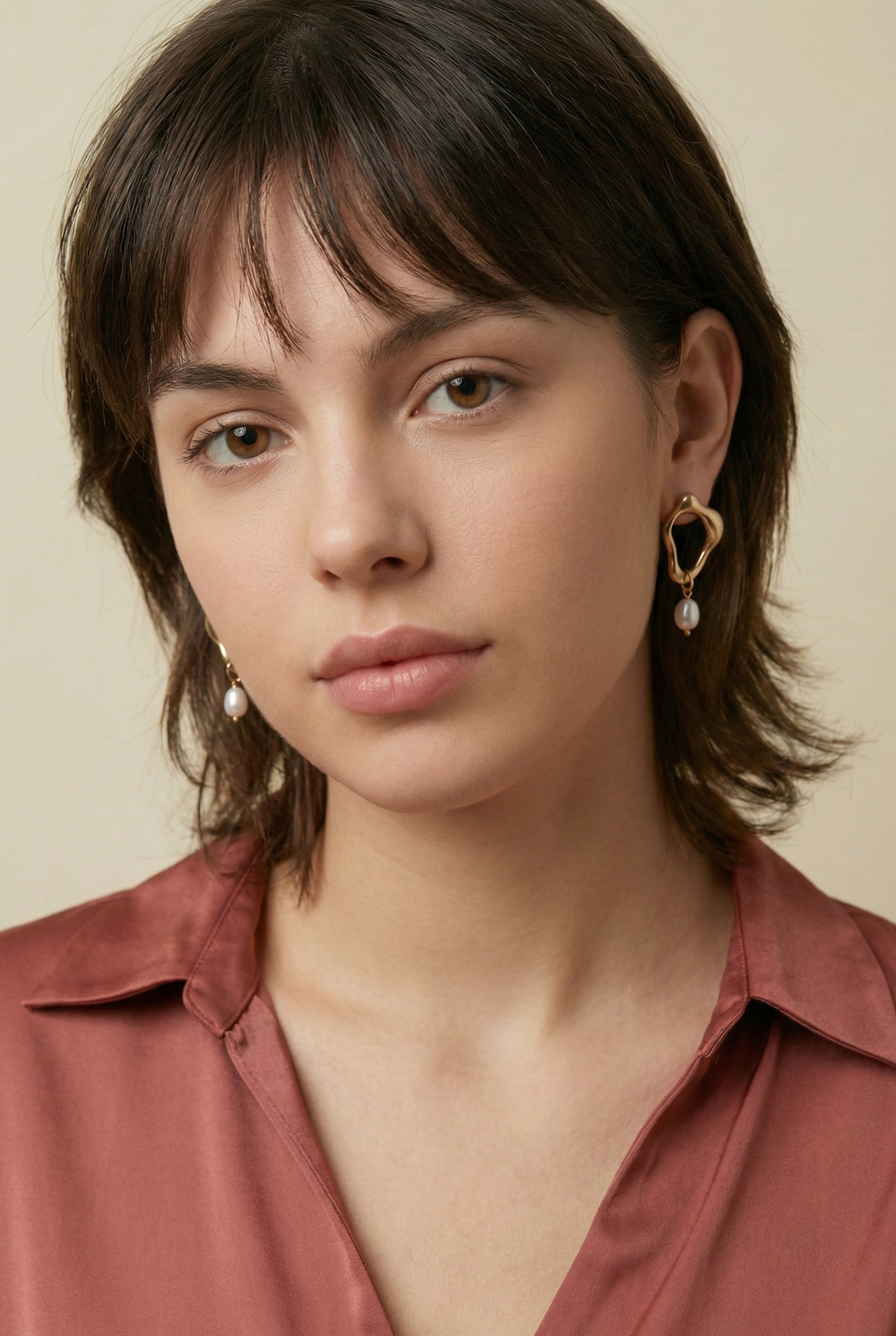 Model wearing modern molten organic gold and AAA grade high lustre pearl drop earrings