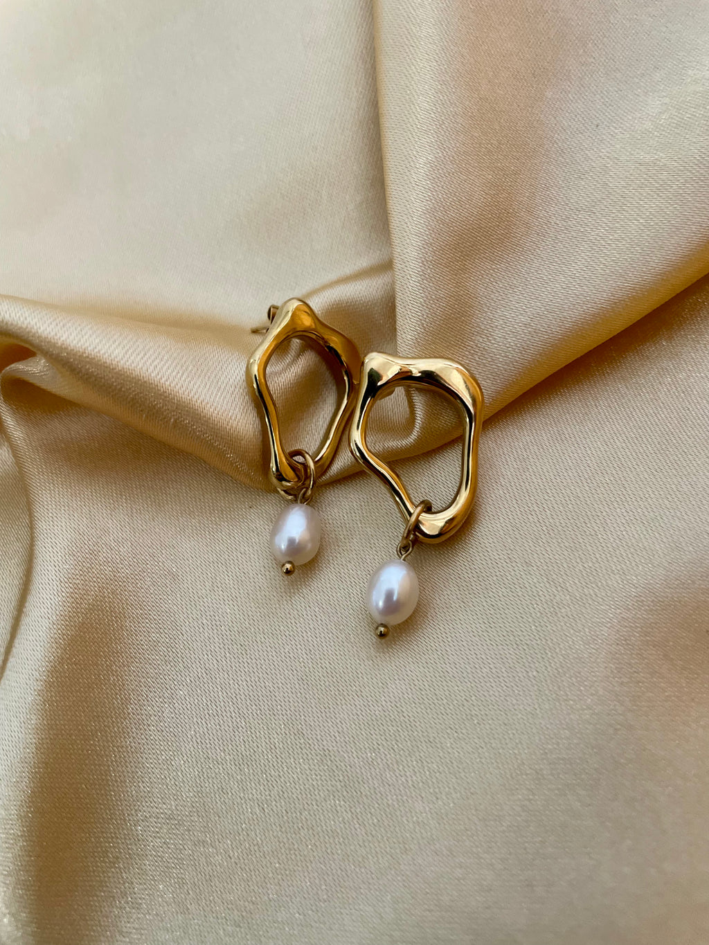 woman wearing sculptural gold earrings with a delicate freshwater pearl drop, ideal for weddings, office and casual night outs
