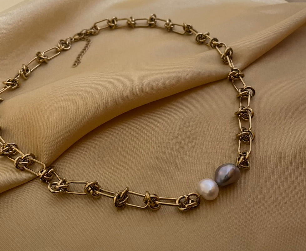 Close-up of a AAA grade baroque pearl necklace featuring a duo of white and silver-grey pearls on a chunky gold paperclip chain