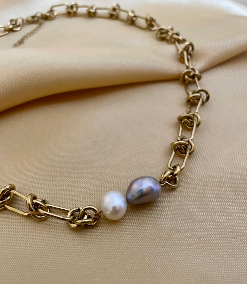Close-up of a AAA grade baroque pearl necklace featuring a duo of white and silver-grey pearls on a chunky gold paperclip chain