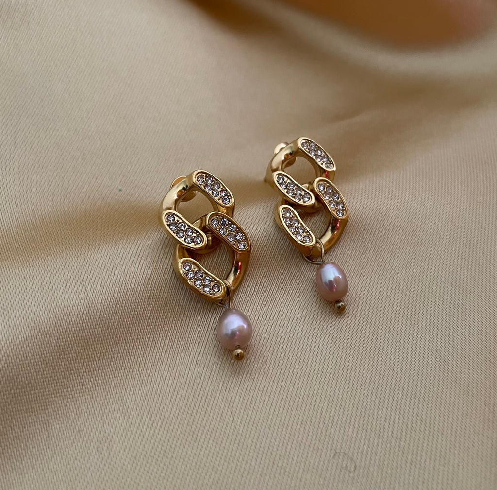 Woman wearing gold and diamond earrings with pink freshwater pearls