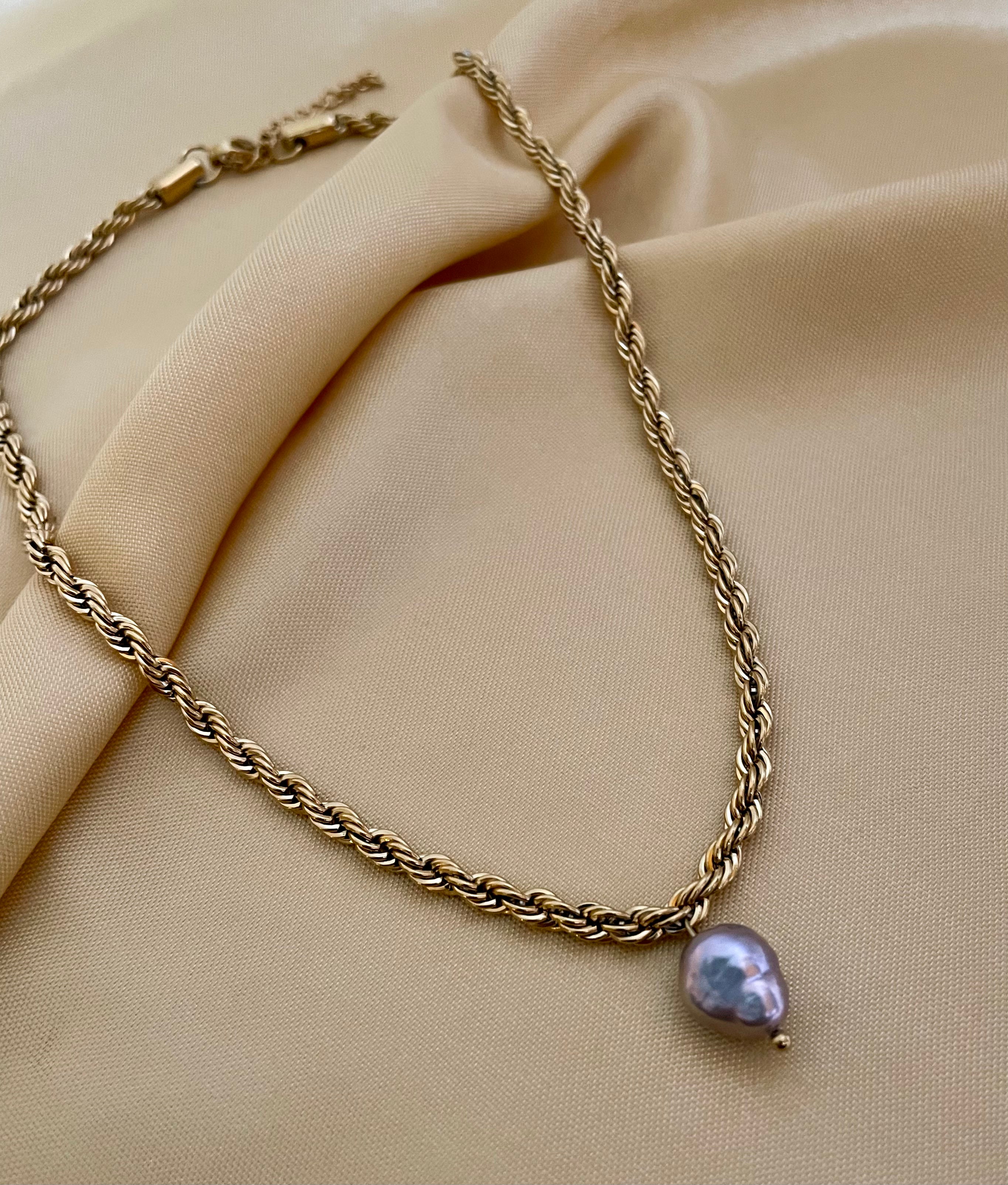 Featuring a bold, architectural rope chain, this piece serves as the perfect pedestal for a single, magnificent AAA-grade grey baroque pearl.
