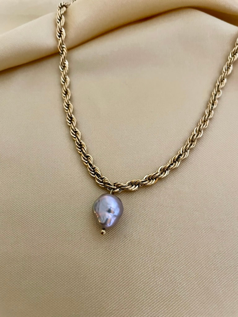 Featuring a bold, architectural rope chain, this piece serves as the perfect pedestal for a single, magnificent AAA-grade grey baroque pearl.